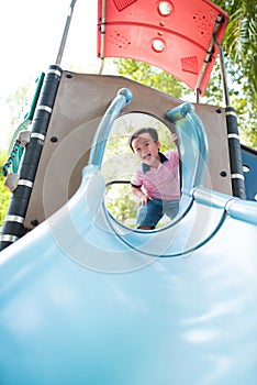 Happy little boy having fun at playground in summer.