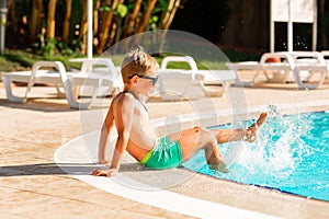 Happy little boy having fun at the pool at the resort