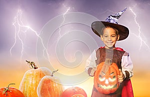 Happy little boy hold spooky Halloween pumpkin