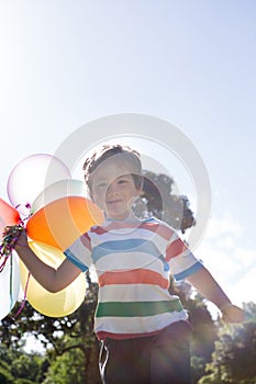 Happy little boy holding balloons