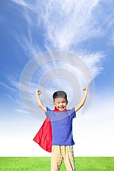 Happy little boy imitate superhero and open arms with blue sky