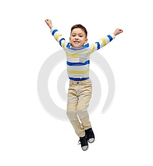 Happy little boy jumping in air