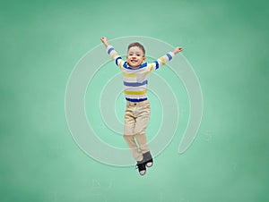 Happy little boy jumping in air over school board