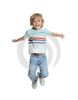 Happy little boy jumping on white