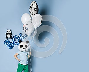 Happy little boy kid in panda mask with bunch of balloons for birthday part.  Translation  from Russian on balloon: I love you