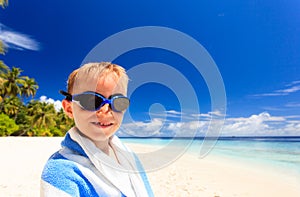 Happy little boy laugh wrapped in beach towel