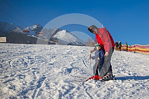 Happy little boy learning skiing with his father in Slovakia