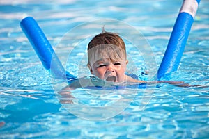 Happy little boy learning to swim