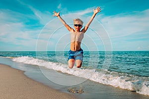 Happy little boy play on beach, kid enjoy vacation