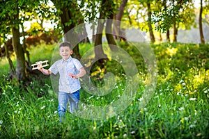 Happy little boy is playing with an airplane model