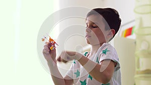 Happy little boy playing with airplane toy at home