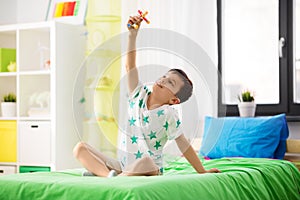 Happy little boy playing with airplane toy at home