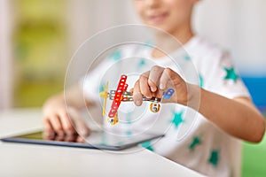 Happy little boy playing with airplane toy at home