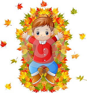 Happy little boy playing with autumn leaves