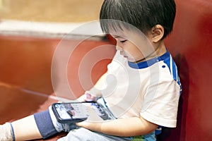 Happy little boy playing online game with mobile phone