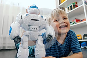 happy little boy playing with robot toy at home