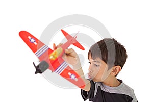 Happy little boy playing with toy airplane