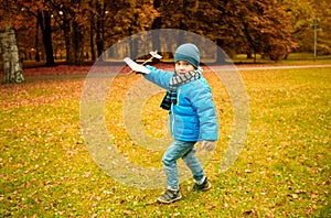 Happy little boy playing with toy plane outdoors