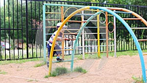 Happy little boy plays on children playground