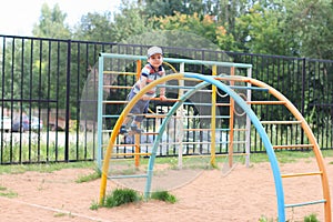 Happy little boy plays on children playground