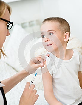 Happy little boy receiving injection or vaccine