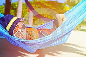 Happy little boy relaxed in hammock on the beach