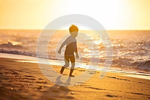 Happy little boy running on beach.