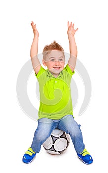 Happy little boy sitting on soccer ball