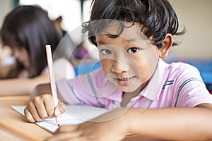 Happy little boy studying in the classroom