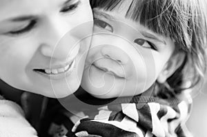 Happy little boy tenderly leaning to his mom, bw shot
