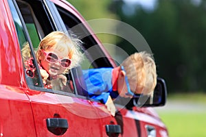Happy little boy and toddler girl travel by car