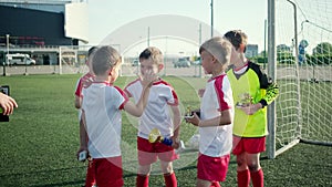 Happy little boys footballers are rejoicing by win