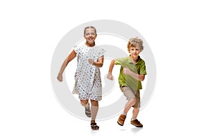 Happy little caucasian girl and boy jumping and running isolated on white background