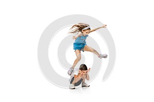 Happy little caucasian girl and boy jumping and running isolated on white background