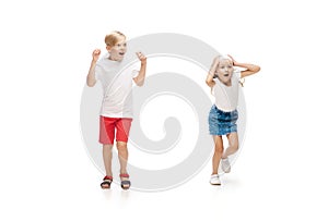 Happy little caucasian girl and boy jumping and running isolated on white background