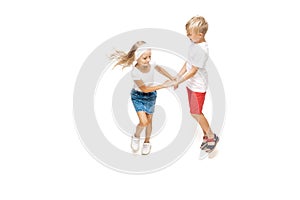 Happy little caucasian girl and boy jumping and running isolated on white background