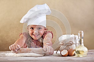 Happy little chef stretching the dough