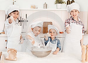 Happy little chefs preparing dough in the kitchen