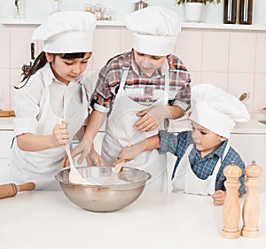 Happy little chefs preparing dough in the kitchen