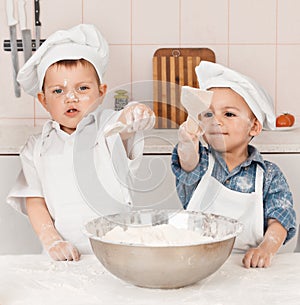 Happy little chefs preparing dough in the kitchen
