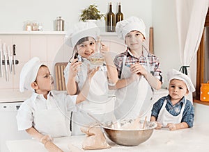 Happy little chefs preparing dough in the kitchen