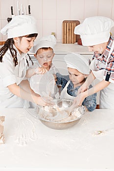 Happy little chefs preparing dough in the kitchen