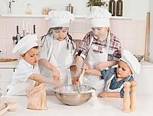 Happy little chefs preparing dough in the kitchen