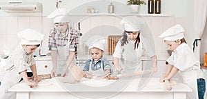 Happy little chefs preparing dough in the kitchen