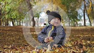 Happy little child, baby boy laughing and playing in the autumn in the park walk outdoors.