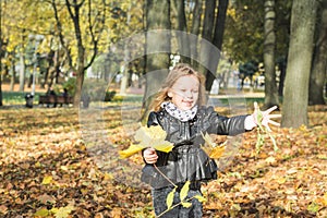 Happy little child, baby girl laughing and playing in the autumn