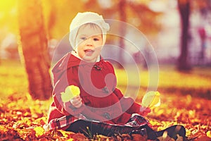 Happy little child, baby girl laughing and playing in autumn