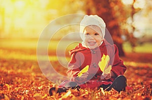 Happy little child, baby girl laughing and playing in autumn