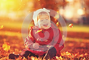 Happy little child, baby girl laughing and playing in autumn