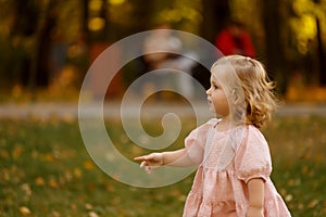 happy little child, baby girl laughing and playing in the autumn on the nature walk outdoors